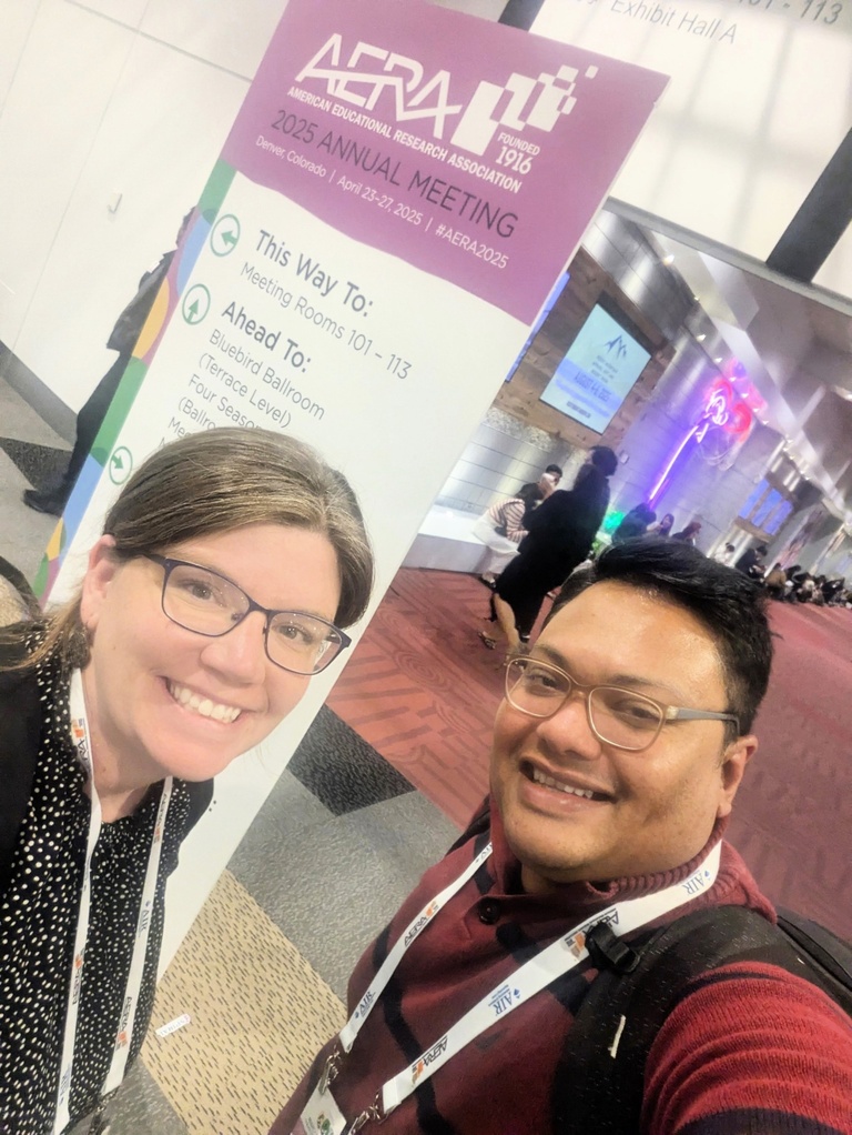 Two students take a selfie together at AERA