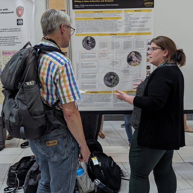 Mandy explains her poster at AERA.
